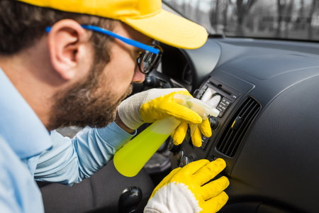 Professional worker using disinfectant to clean car dashboard.の写真素材