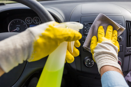 Man cleansing car dashboard and spraying with disinfection liquid.の写真素材