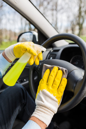 Close up of car wash worker disinfecting vehicle interior.の写真素材