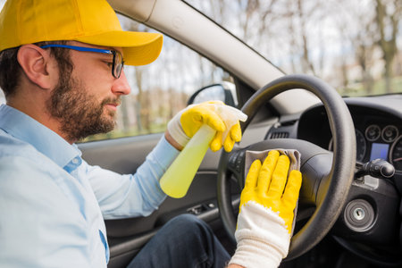 Car wash worker disinfecting vehicle interior.の写真素材
