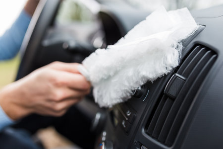 Driver using soft microfiber cleaning brush duster cleaner on car dashboard.の写真素材