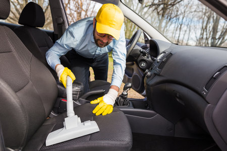 Professional worker cleaning vehicle interior textile seats with vacuum cleaner.の写真素材