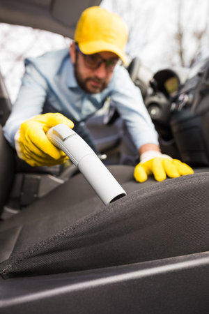 Man vacuuming passenger seat, car wash, and cleaning concept.の写真素材