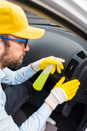 Man cleansing car vent grille air duct with disinfection liquid.の写真素材