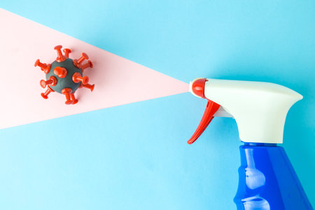 Spray bottle of disinfectant destroying corona virus cell minimal creative concept.の写真素材
