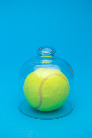 Tennis ball under glass cover isolation covid-19 abstract.の写真素材