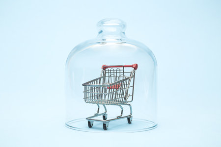 Shopping trolley in isolation under glass cover covid-19 abstract.の写真素材
