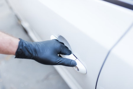 Driver with surgical protective gloves opening car door. Coronavirus prevention.の写真素材