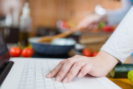 Woman cooking healthy meal. Food blog concept. Work from home multitasking.の写真素材