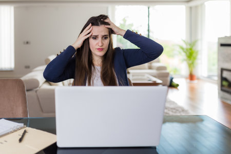 Young businesswoman working on laptop from home under stress. Business problems concept.の写真素材