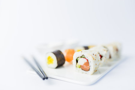 Sushi rolls and nigiri meal set with chopsticks, soy sauce, wasabi and gari on table.の写真素材