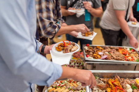 Buffet concept on event at restaurant. Close up of man holding plate full of food.の写真素材