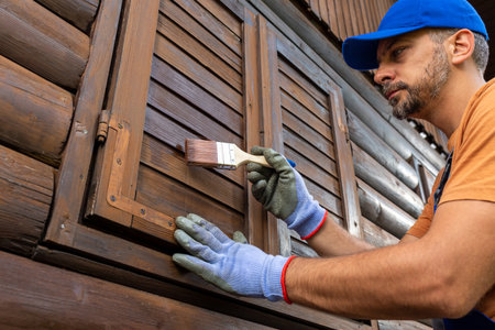 Protecting wooden house exterior with applying stain or paint.の写真素材
