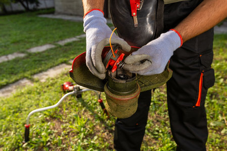 Man installing a string for cutting grass in his garden.