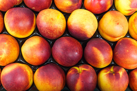 Red-yellow nectarines in a drawer on the tableの写真素材