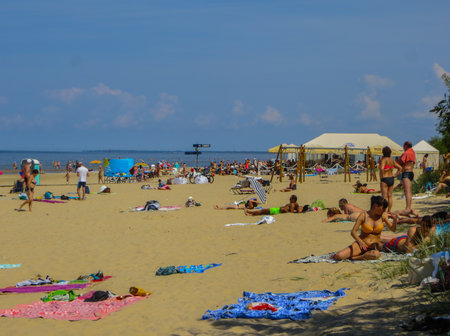 Jurmala, Latvia - 29 July, 2018: People enjoy the sunny spring day on the Baltic sea gulf beach in Jurmala resort, Latvia.のeditorial素材
