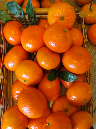 Ripe orange mandarins in a wooden tray on the table.の写真素材