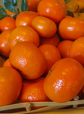 Ripe orange mandarins in a wooden tray on the table.の写真素材