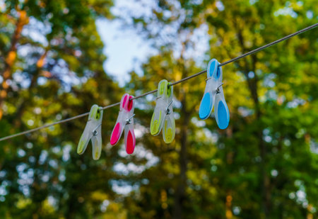 multi-colored four clothes pegs attached to a long rope in the courtyardの写真素材