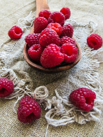 Fresh, red raspberries in a wooden spoon