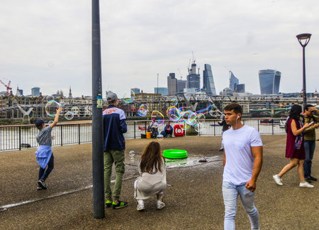 A young man blows soap bubbles on the Thamesのeditorial素材