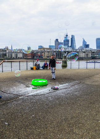 A young man blows soap bubbles on the Thamesのeditorial素材