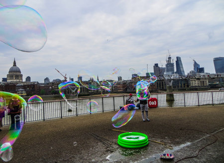 A young man blows soap bubbles on the Thamesのeditorial素材