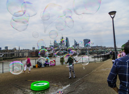 A young man blows soap bubbles on the Thamesのeditorial素材