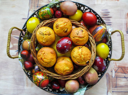 Multicolored eggs, boiled and painted by hand, and small cupcakes cooked for Easter.