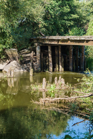 Old dilapidated wooden bridge over the riverの写真素材