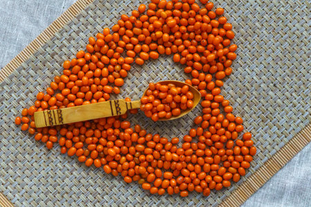 Brightly orange sea-buckthorn berries are scattered on the table