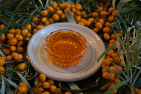 bunches of ripe, orange sea-buckthorn on branches with sea-buckthorn oilの写真素材