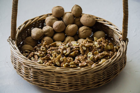 Walnuts peeled and in shells on a table in a basketの写真素材