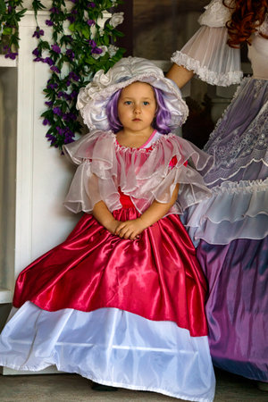 Beautiful little girl dressed in a luxurious vintage red dress.Puppet Museum, July 2020 in Preili, Latvia.のeditorial素材