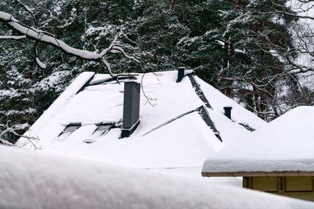 White snow is falling on the roof covered with snowの写真素材