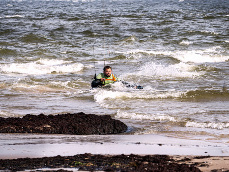 A young man is engaged in extreme kiteboarding in the Gulf of Riga on October 21, 2020 at Cape Kolka in Latvia.のeditorial素材