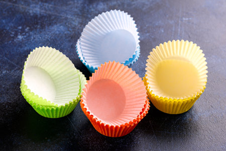 Empty cupcake cases, forms on blue background, table.の写真素材