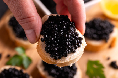 Slices of bread with black caviar on rustic dark background.の写真素材