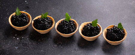Tartlets with black caviar on rustic background.の写真素材