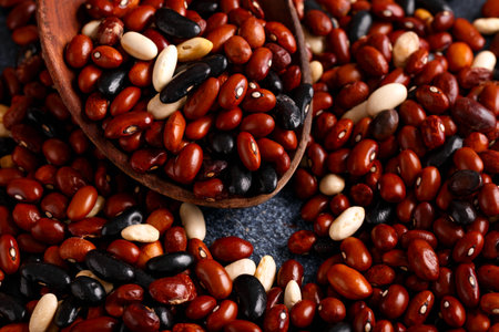 Dried red beans and black, white mix on rustic table.
