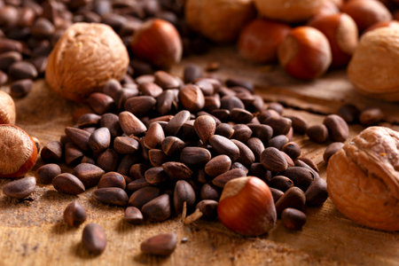 Siberian pine nuts, hazelnuts and walnuts on wooden board.