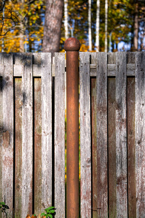 Old wooden fence. The fence is supported by rusty metal posts.