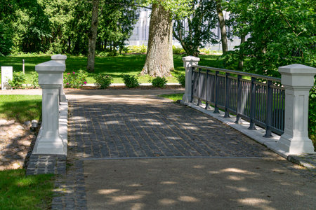 A beautiful, restored bridge over the river in an old park in Latviaの写真素材