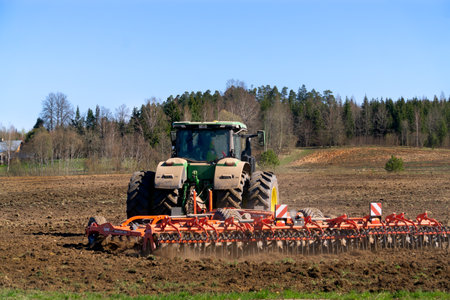 A tractor plows a field in early spring.