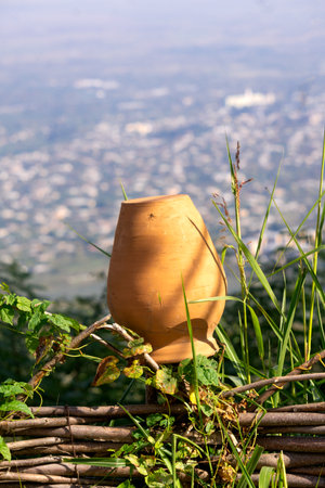 An old traditional clay jug hangs on a wooden fenceの写真素材