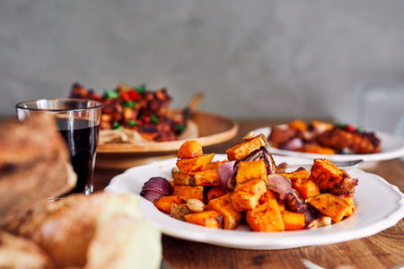 Low angle view of table served with traditional British Sunday roast dinner, featuring roasted chicken, squash and sweet potatoesの写真素材