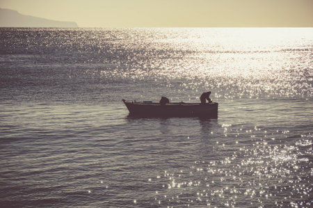 Fisherman at sunset in the waters of the Gulf of Naplesの写真素材