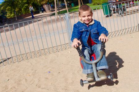 Little boy swinging on the playgroundの写真素材