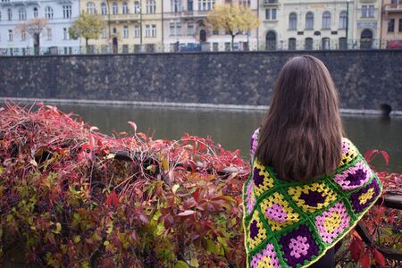 Girl standing on the bridge, surrounded by colors of the autumn season