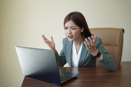 a female worker is working at her desk using a laptopの写真素材